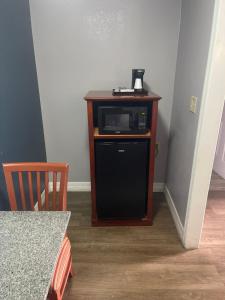 a microwave sitting on top of a wooden stand at Days Inn by Wyndham Orange City/Deland in Orange City