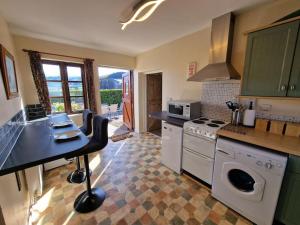 a kitchen with a table and a stove top oven at Swallows Nest in Abergavenny