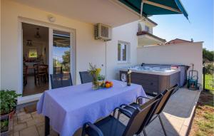einen Tisch mit einem blauen Tischtuch auf einer Terrasse in der Unterkunft Nice Home In Marcelji With Jacuzzi, 2 Bedrooms And Wifi in Marčelji