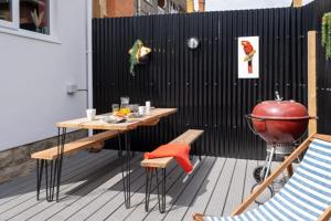 a patio with a grill and a table and chairs at Ultimate glam, vintage central pad. Cool 70s bar. in Bournemouth