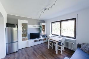 eine Küche und ein Esszimmer mit einem Tisch und einem Kühlschrank in der Unterkunft Ferienwohnung "Am Skilift" in Herrischried