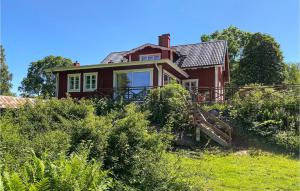 a red house in the middle of a field at Awesome Home In Trans With Kitchen in Tranås