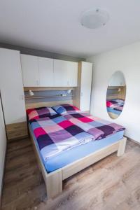een slaapkamer met een bed met een kleurrijk dekbed bij Ferienwohnung "Am Skilift" in Herrischried