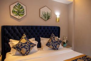 um quarto com uma cama com uma cabeceira e almofadas pretas em VANCII Hotel em Chefchaouen