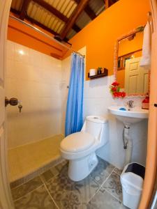 e bagno con servizi igienici, lavandino e doccia. di Hostal Koltin Suchitoto a Suchitoto