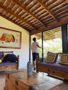 a man is looking out the window of a room at Casa Camino a las Pozas in Xilitla
