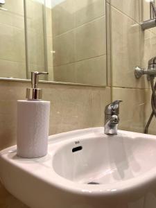 a bathroom sink with a soap dispenser on it at Abrigo and Restaurant Portinho in Vila Praia de Âncora