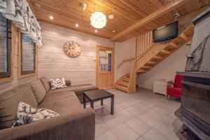 un soggiorno con un divano e una TV di Villa ArcticFox Levi a Kittilä