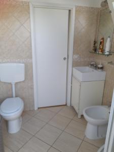 a bathroom with a toilet and a sink at CasaMya in SantʼAntìoco