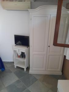 Habitación con puerta blanca y TV. en CasaMya, en SantʼAntìoco