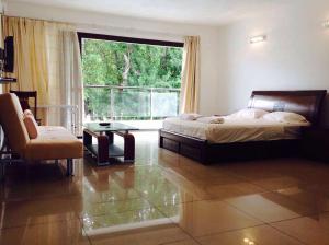 a bedroom with a bed and a large window at Silver Sands in Flic-en-Flac