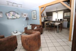 - un salon avec des canapés et une salle à manger dans l'établissement gite des 3 rivières, à Longeault