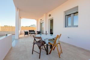 a dining room with a table and chairs at House on the black beach with sea view and parking in Agios Georgios Thalassiti