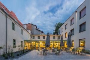 un patio con mesas, sillas y sombrillas en Hotel ETER, en Toruń