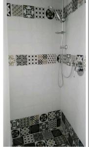 a bathroom with black and white tiles and a shower at sacrobosco apartment Pioppo in Bomarzo