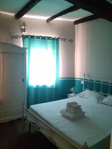 1 dormitorio con 1 cama con sábanas blancas y ventana en sacrobosco apartment Quercia, en Bomarzo