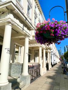 a building with a bunch of flowers hanging from it at Melbourne House Hotel in London
