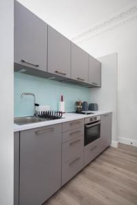 a kitchen with white cabinets and a sink at Modern Studio Apartment in prime central location in Edinburgh