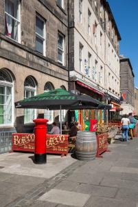 a table with an umbrella in front of a building at Modern Studio Apartment in prime central location in Edinburgh