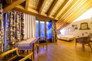 ティラーノにあるBernina Express Eco Rooms&Breakfastのベッド、テーブル、椅子が備わる客室です。