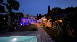 a house with a swimming pool at night at vraxleri house in Kassiopi
