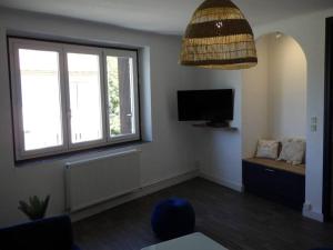 sala de estar con TV y ventana en Spacieux appartement au pied de la cité médiévale en Carcassonne
