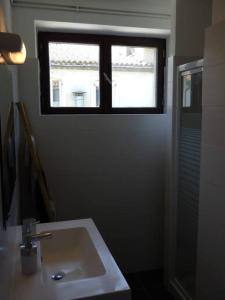 baño con lavabo y ventana en Spacieux appartement au pied de la cité médiévale, en Carcassonne