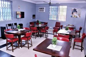 a dining room with tables and red chairs at Lady M guest House in Tema