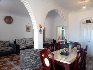 een woonkamer met een tafel en stoelen bij DAR EL CADI -Quaa Assrasse- in Kaa Asras