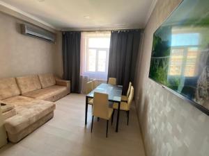 a living room with a couch and a table at Green Park in Aktau +10 photos