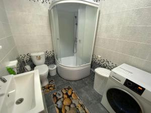a bathroom with a shower and a washing machine at Green Park in Aktau