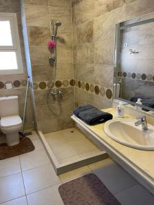 een badkamer met een douche, een wastafel en een toilet bij Villa Telal Ain Sokhna in Ain Sokhna