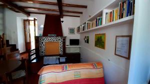 une chambre avec un lit et des livres sur un mur dans l'établissement L'Olivo, à San Michele in Teverina
