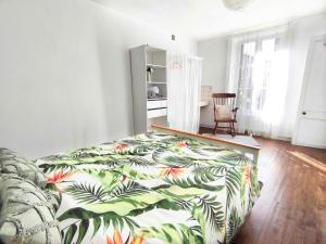 een slaapkamer met een bed met een tropische print bij Number 22 - Le Dorat - Apartment One in Le Dorat