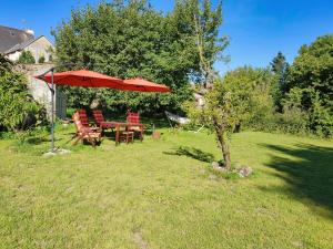 een tafel en stoelen onder een paraplu in een tuin bij Number 22 - Le Dorat - Apartment One in Le Dorat