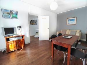 een woonkamer met een tafel en stoelen en een televisie bij Number 22 - Le Dorat - Apartment One in Le Dorat