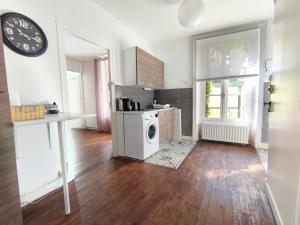 een keuken met een wasmachine en een klok aan een muur bij Number 22 - Le Dorat - Apartment One in Le Dorat
