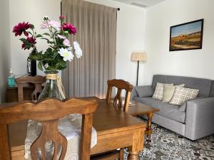 una sala de estar con un jarrón de flores sobre una mesa en La Casa de Adela, en Táliga