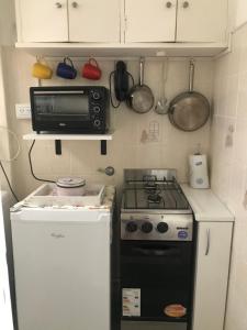 eine kleine Küche mit einem Herd und einer Mikrowelle in der Unterkunft Hermosos atardeceres … in Mar del Plata