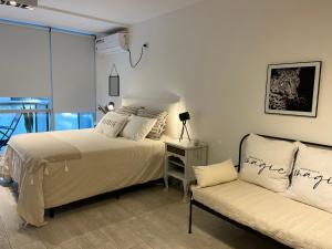 1 Schlafzimmer mit 2 Betten und einem Sofa in der Unterkunft City Madero Buenos Aires in Buenos Aires