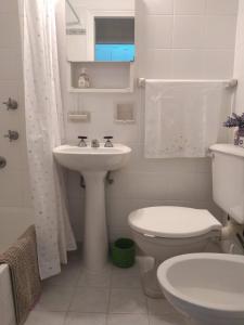 Un baño blanco con inodoro y lavabo. en Hermosos atardeceres …, en Mar del Plata