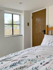 a bedroom with a bed and a window at The Hut in Ross on Wye
