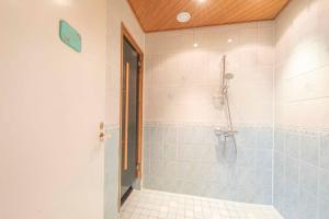 Un baño con ducha con puerta de cristal. en Villa ArcticFox Rovaniemi, en Rovaniemi 22 fotos más
