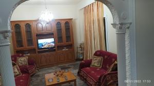 a living room with two chairs and a television at Anesis Home. in Tríkala
