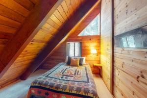 a bedroom in a log cabin with a bed at Tahoe Pines Cabin in Homewood