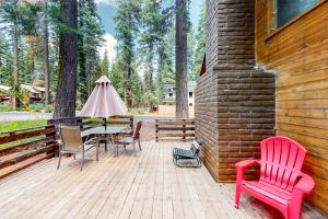 a patio with a table and chairs on a wooden deck at Tahoe Pines Cabin in Homewood