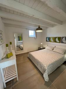 a bedroom with a bed and a table and a mirror at La Bouganville in Avola