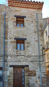 un edificio de piedra con 2 ventanas y una puerta en Casa Rural Bella Culla en Culla