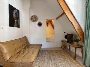 uma sala de estar com um sofá e uma mesa em Tiny Private City Rooms Haarlem em Haarlem
