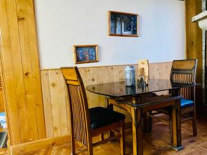 a dining room table with chairs and a wooden table at Vashisht valley hotel in Manāli